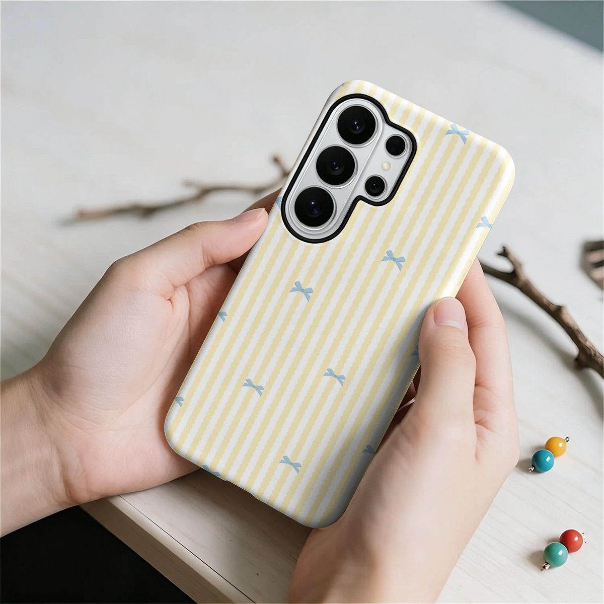 ブルーリボンと黄色のストライプがデザインされた、2層構造の2 - Samsung Galaxy S24 のレビューと価格